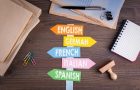 languages concept, English, Italian, German, French, Spanish. Paper signpost on a wooden desk languages concept, English, Italian, German, French, Spanish. Paper signpost on a wooden desk